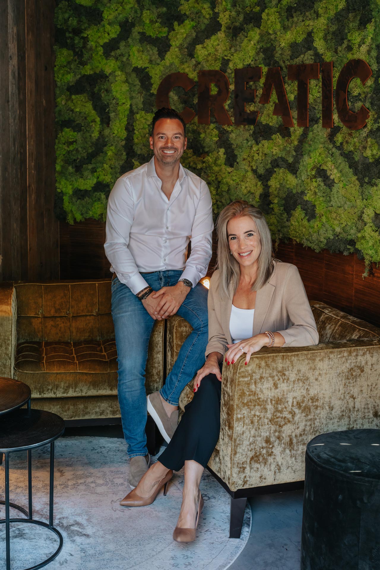 Rob en Babette van Creatic Digital Agency poseren voor de mosmuur met het Creatic-logo
